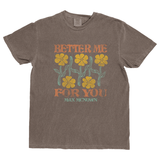 Brown tee featuring yellow and green flower design with orange text that reads "Better Me For You" and green text that reads "Max McNown"