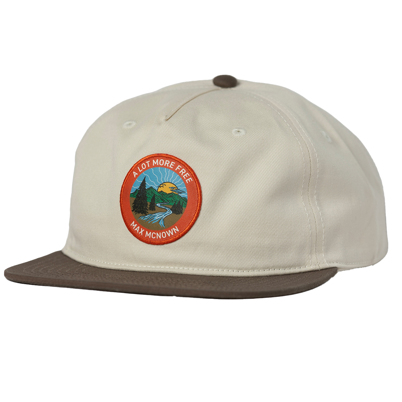 two tone white and brown hat with orange patch featuring a nature landscape design